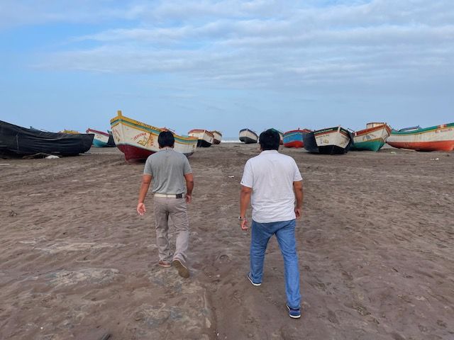 Pescadores caminan entre barcos amarrados en la playa de San José. 