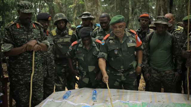 Imagem de dezembro de 2021 mostra Camille Bombele, coordenador da iniciativa conjunta entre RDC e Uganda, conversando com oficiais no quartel-general do Parque Nacional de Virunga