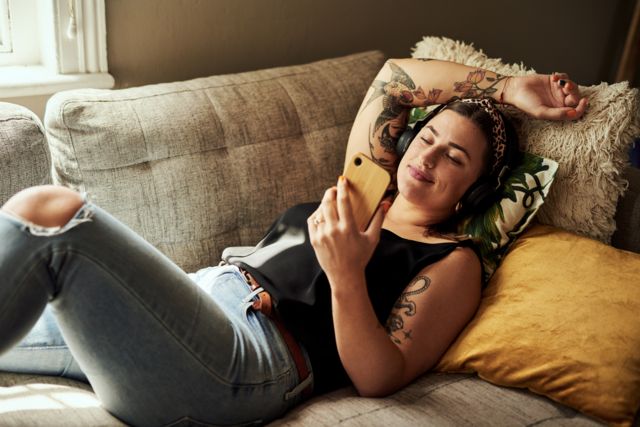 Mulher tatuada ouvindo música