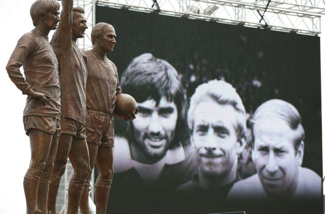  На стадионе «Манчестер Юнайтед» стоит памятник так называемой «святой троице» самых знаменитых игроков клуба в истории: Бобби Чарльтону (крайний справа), Денису Лоу и Джорджу Бесту (слева)