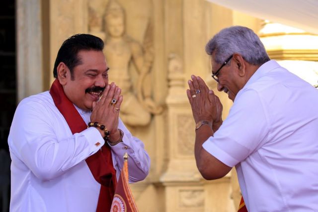 Sri Lankan president Gotabaya Rajapaksa greets after handing over the appointment documents to his brother, former president, Mahinda Rajapaksa (L) who took oaths as the prime minister at Kelaniya Raja Maha Viharaya, in Colombo, Sri Lanka on August 9, 2020