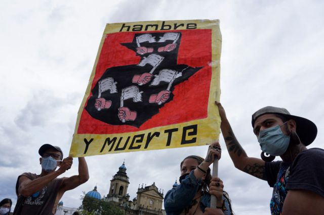 La gente levantando un cartel que dice hambre y muerte