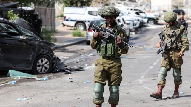Soldados israelenses fazem patrulha perto de uma delegacia de polícia que foi palco de uma batalha após uma infiltração em massa de homens armados do Hamas vindos da Faixa de Gaza