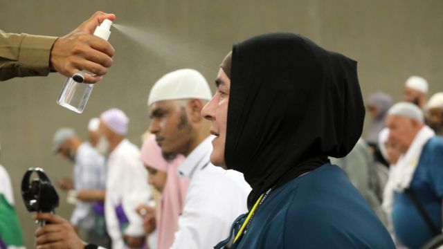 Mão de guarda joga spray com água em senhora com véu