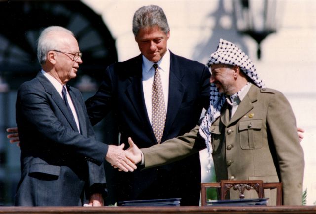 Foto de arquivo mostra Bill Clinton mediando aperto de mãos entre Yasser Arafat e Yitzhak Rabin