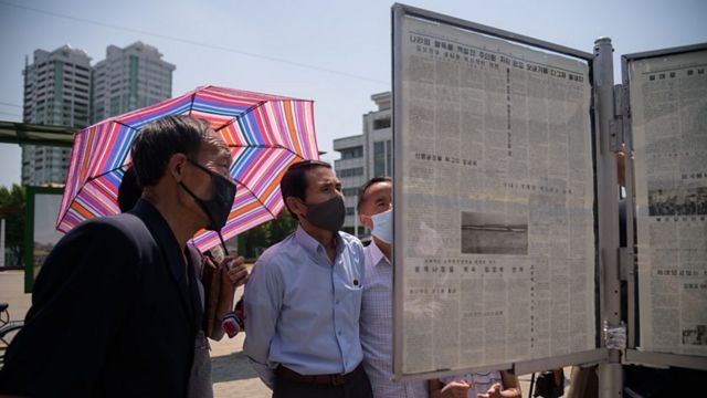 شهروندان پیونگ یانگ روزنامه رودونگ سینمون (Rodong Sinmun) را در یک جایگاه عمومی می‌خوانند
