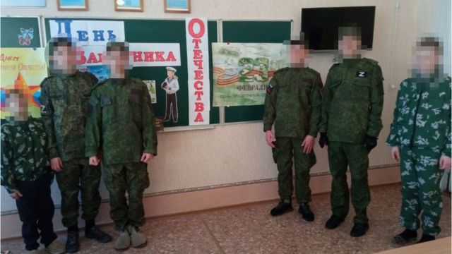 Crianças ucranianas vestindo uniformes militares da Rússia