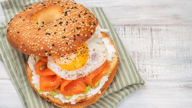 Bagel recheado com cream cheese, salmão defumado, abacate e ovo  frito