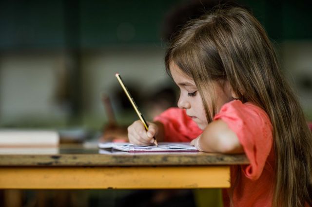 Niña escribiendo en un cuaderno