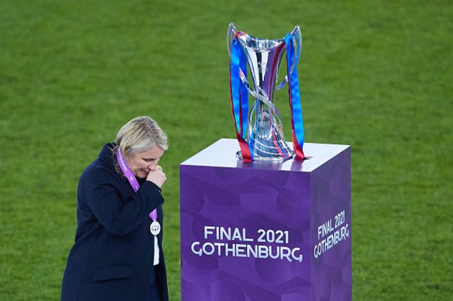 Emma Hayes, manager of Chelsea FC reacts walking past the Champions League trophy