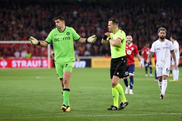 Aston Villa goalkeeper Emiliano Martínez is booked during their shootout win over Lille