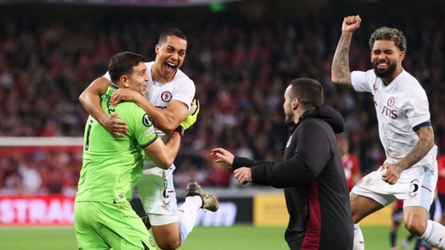 Aston Villa goalkeeper Emiliano Martinez is mobbed by his team-mates after his heroics in their penalty shootout win over Lille