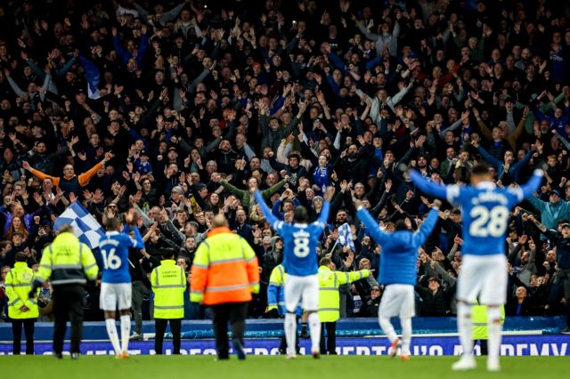 Everton players and fans celebrate their win over Liverpool