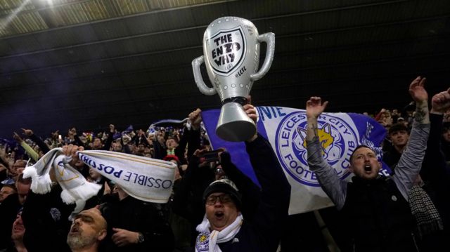Leicester fan celebrates with a blow-up trophy