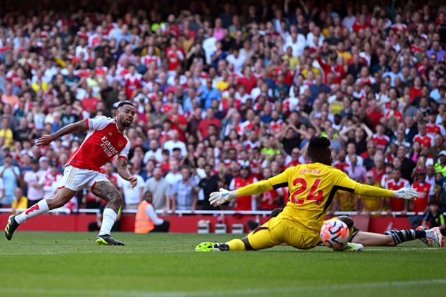 Gabriel Jesus of Arsenal scores the team's third goal past Andre Onana