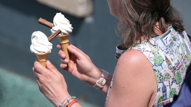 Woman holding two ice creams