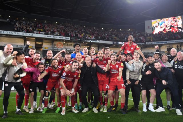 Crawley Town players and staff celebrate reaching the League Two play-off final