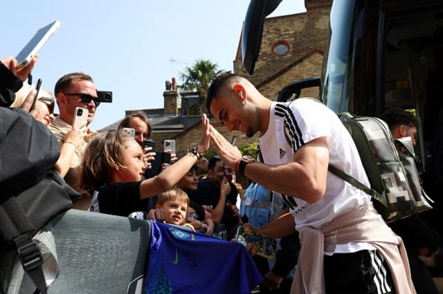 Andreas Pereira (R) is greeted by supporters as he arrives