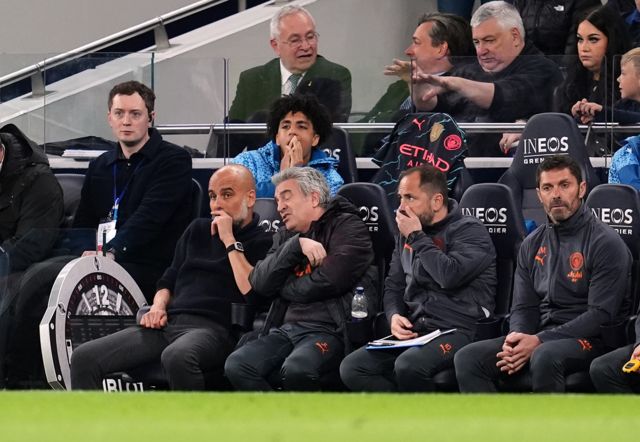 Guardiola sits on the bench chatting to his staff