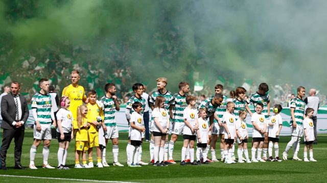 Celtic players line-up in front of a wall of smoke