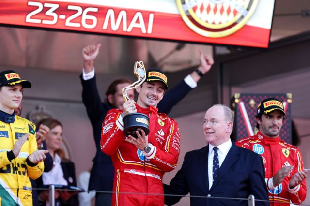 Charles Leclerc poses with the winner's trophy