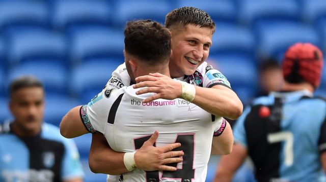Luke Morgan of Ospreys celebrates with team mates after scoring a try