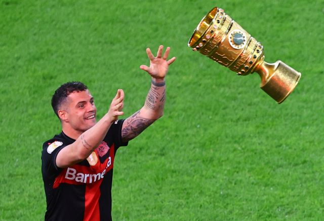 Bayer Leverkusen's Granit Xhaka poses for a picture with the trophy after winning the DFB Cup