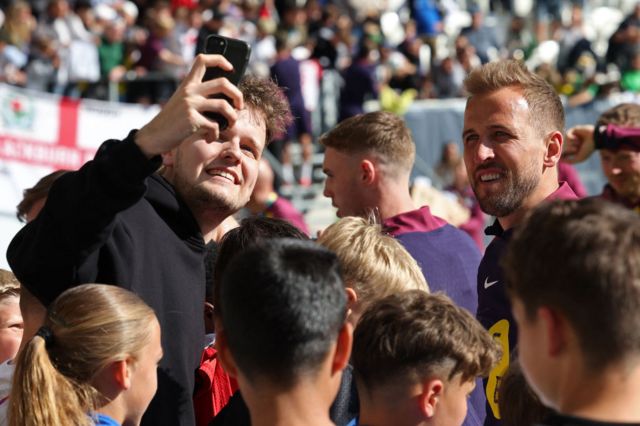 Harry Kane taking pictures with fans