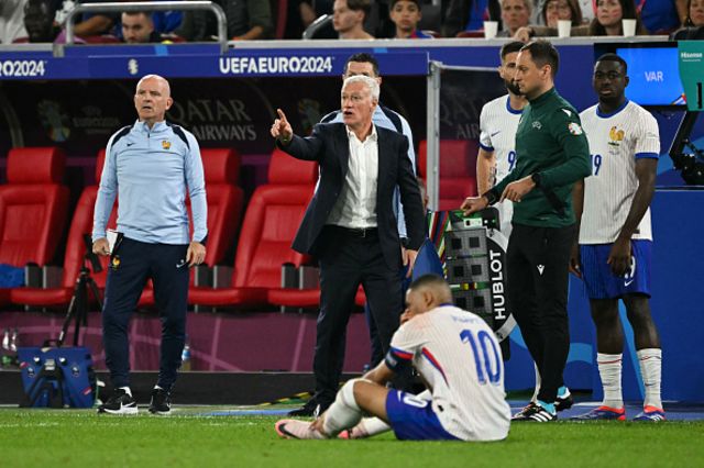 idier Deschamps reacts as France's forward #10 Kylian Mbappe sits on the football pitch