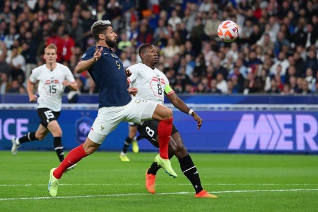 France's forward Olivier Giroud (L) controls the ball ahead of Austria's defender and captain David Alaba