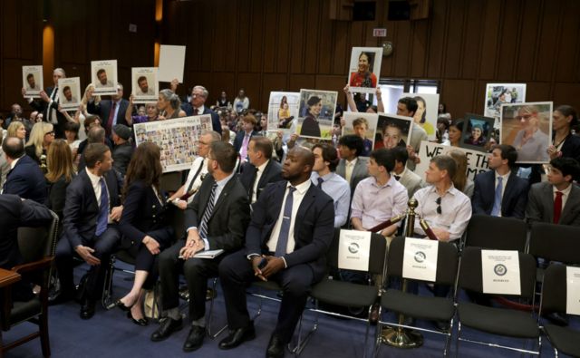 Family members of victims of Boeing crashes hold signs in a senate hearing