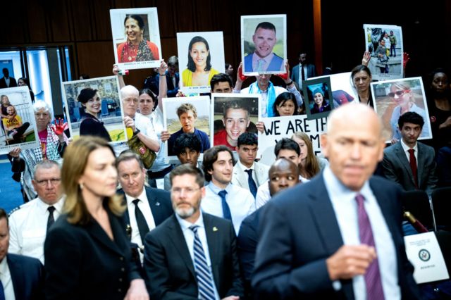 Relatives of Boeing Co. airplane crash victims hold images as Dave Calhoun, chief executive officer of Boeing Co., arrives for a Senate Homeland Security and Governmental Affairs Permanent Subcommittee on Investigations