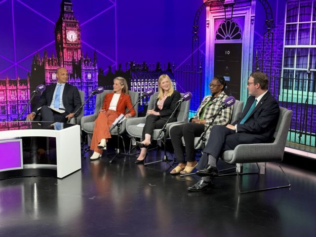 View inside the studio with candidates sat on chairs with a purple background