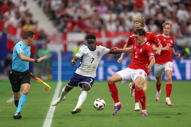 Bukayo Saka of England runs with the ball under pressure