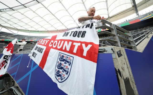 England fan pins up a St George's flag inside the stadium