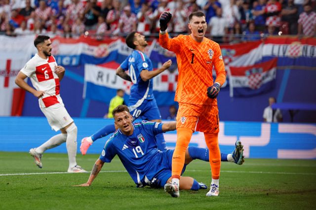 Mateo Retegui falls as Croatia's goalkeeper #01 Dominik Livakovic reacts