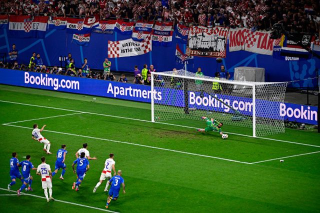 Gianluigi Donnarumma (R) stops a penalty shot by Croatia's midfielder #10 Luka Modric