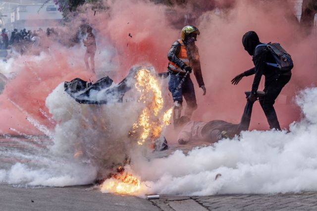 A tear gas canister explodes as protesters try to help injured people outside the Kenya Parliament during a nationwide strike to protest against tax hikes and the Finance Bill 2024 in downtown Nairobi, on June 25, 2024