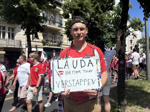 Austria fan holds up sign with 'Lauda better than Verstappen' on it