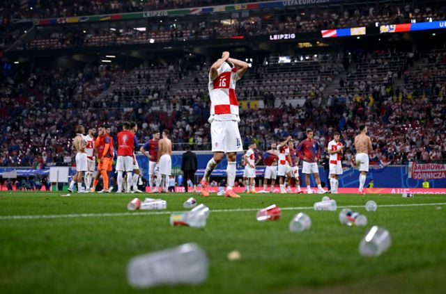 Empty beer cups litter the pitch after Croatia v Italy