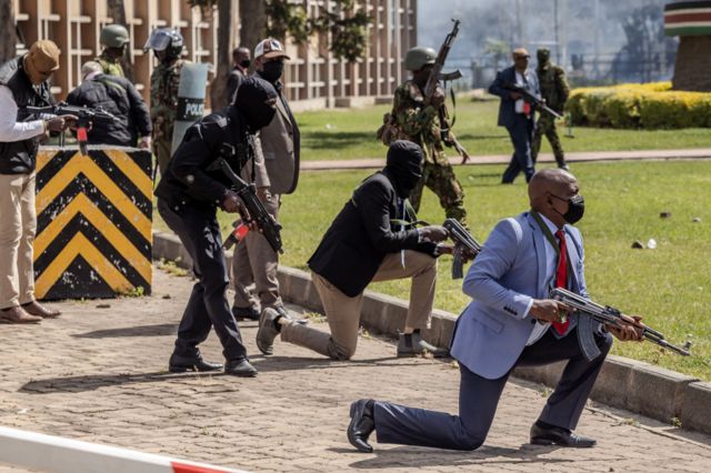 enya Police officers and security personnel take position to protect the Kenyan Parliament as protesters try to storm the building during a nationwide strike to protest against tax hikes and the Finance Bill 2024 in downtown Nairobi, on June 25, 2024.
