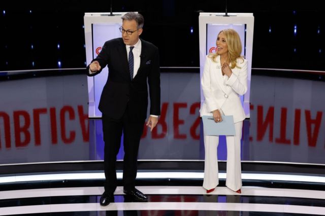 CNN anchors Jake Tapper and Dana Bash stand on stage