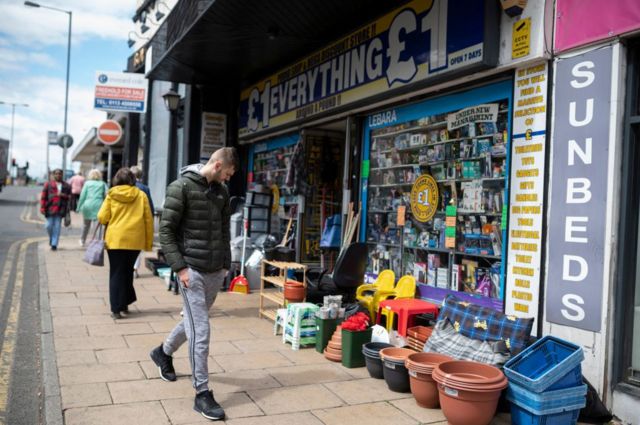 A man inspects the goods outside a discount store in Bradford