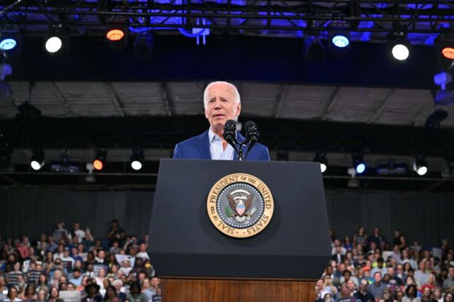 Joe Biden stands in front of a podium