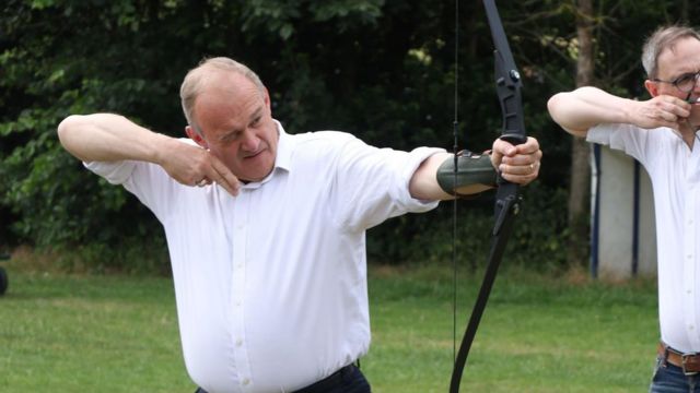 Liberal Democrat leader Sir Ed Davey and local parliamentary candidate Ian Sollom try their hand at archery in Little Paxton, Cambridgeshire, while on the General Election campaign trail.
