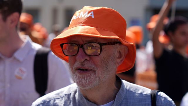 Jeremy Corbyn wears a British Medical Association (BMA) hat among junior doctors on the picket line outside St Thomas' Hospital, London, during their continuing dispute over pay.