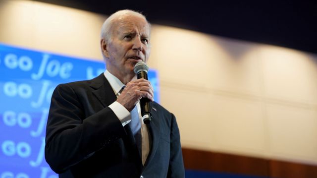 Joe Biden photographed with a microphone in hand addressing supporters at a rally after the debate