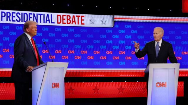 President Joe Biden is seen on the debate stage pointing at Donald Trump