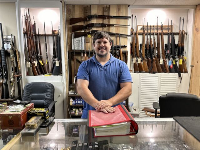 James Ruben poses for a photo inside of his gunshop