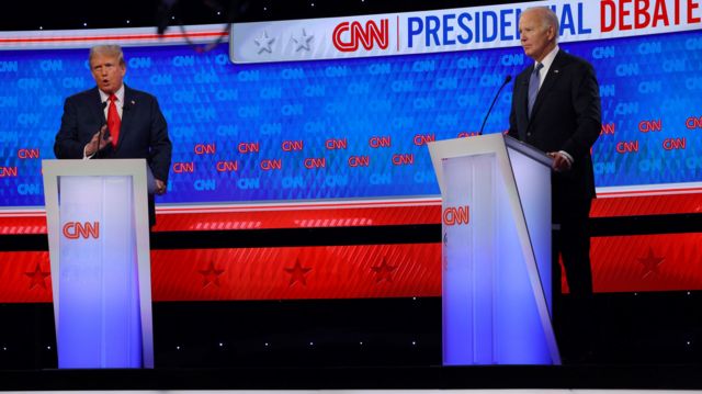Donald Trump motions with his hand while answering a question on the debate stage with President Joe Biden
